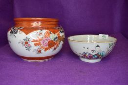 An iron red ground Japanese bowl and similar Canton styled porcelain bowl