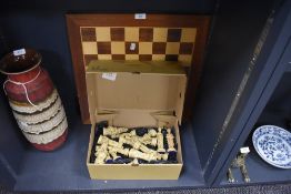 A wooden chess board and a collection of large novelty pieces.