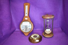 An egg timer and two barometers.