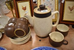 A partial Denby coffee set including cups and saucers,coffee pot and creamer.