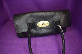 A leather handbag having shoulder strap and brass fitments
