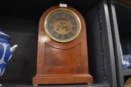 An antique mahogany cased chiming mantle clock having bevelled glass hinged frontage and roman