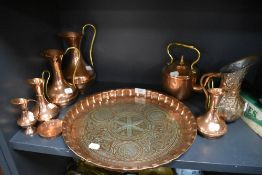 A selection of copper ware including graded jugs, charger, kettle and other similar items.