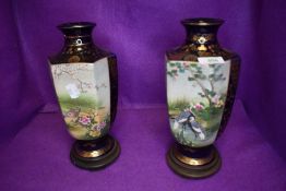 Two large Satsuma vases with stork and cherry blossom design with gilt detailing and wooden stands.