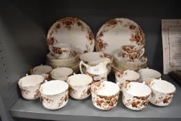 An antique partial tea service including cups and saucers,plates of varying size, jug and sugar