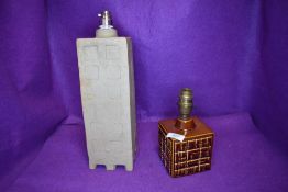 A cubic Poole pottery lamp having brown glaze with abstract design and another taller example in