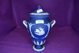 A Wedgwood urn having lidded top and handles to sides,cobalt blue ground with horse and chariot