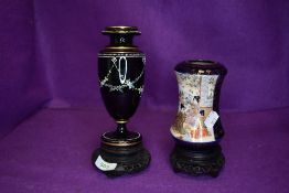 An antique black glass vase with floral swag detail in enamel and a Satsuma vase with gilt detailing