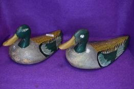 Two genuine wooden carved duck or bird hunting decoys having hand painted mallard style designs some