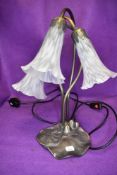 An art nouveau style lamp base having lily pads to base and trumpet shaped fluted glass shades.