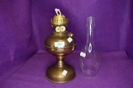 A vintage brass oil lamp having glass chimney.