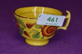 An antique tea cup of small size having hand decoration with mustard yellow glaze and London style