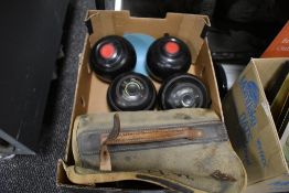 A box of lawn bowls,some in cases,including some wooden ones.
