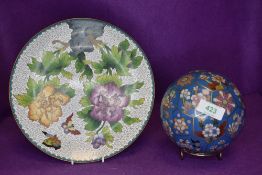 A cloisonne carpet or similar ball and a plate decorated with plants and butterfly