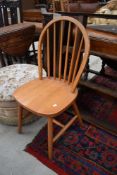 A modern rubberwood kitchen chair, having hoop and stick back