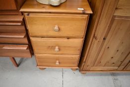 A modern pine bedside chest of three drawers , ply drawer bottoms