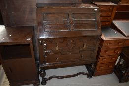 An early 20th Century oak bureau having cushioned flap and drawers, width approx. 73cm