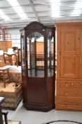 A modern mahogany effect display cabinet, having mirror back