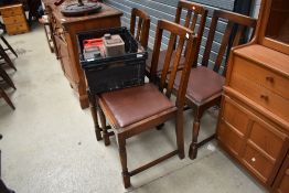 A set of four early to mid 20th Century oak dining chairs having rail backs and drop in vinyl seats