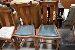 A pair of early 20th Century oak railback dining chairs with green vinyl drop in seats