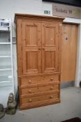 A modern pine natural pine wardrobe having triple drawer base, width approx. 103cm