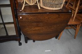 A reproduction oak gateleg dining table