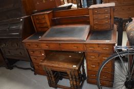 A late 19th or early 20th Century oak desk of interesting design with central writing slope and