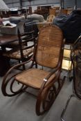 A traditional stained frame and cane bentwood rocker
