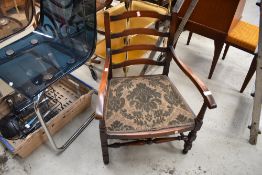 A traditional stained frame low seat carver chair having ladder back