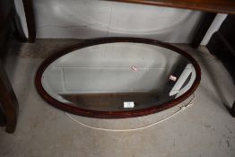 A stained frame oval wall mirror, width approx. 72cm