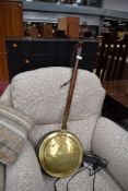 A traditional copper and brass warming pan