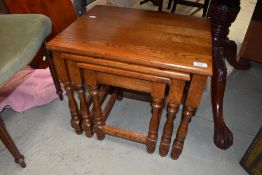 A reproduction golden oak nest of occasional table