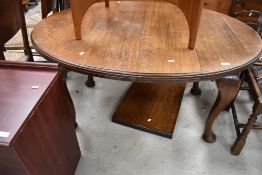 A late 19th Century/early 20th Century oak oval wind out dining table, on heavy cabriole legs