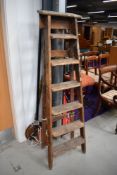 A set of vintage wooden stepladders, tree lopper and two traditional warming pans