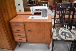 A vintage teak cased Singer electric sewing machine, stylised cabinet in G plan style, width approx.