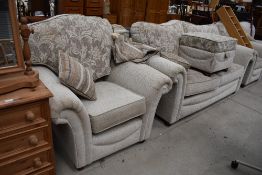 A modern lounge suite, comprising settee , two arm chairs and a pouffe , labelled Ideal upholstery
