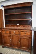 An 19th Century part oak and cross banded dresser , plate racking having three drawers to base, over
