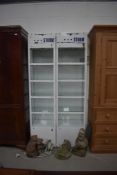 A pair of metal frame and glass shop display cabinets, with lighting