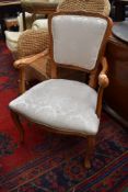 A reproduction French style stained frame and upholstered armchair