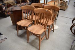 A set of four modern rubber wood slat back kitchen chairs having solid seats on turned legs