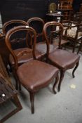 A set of four Victorian balloon back dining chairs (as found, one with damaged rail)