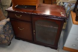 A mahogany effect hifi cabinet, labelled J E Coyle