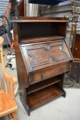 An early 20th Century oak bureau having shelves over and under, width approx. 74cm