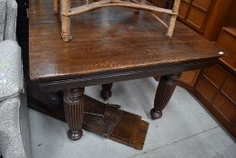 A late Victorian oak windout dining table having fluted legs, winder and four additional leaves
