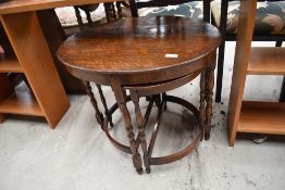 An early 20th Century oak nest of tables, having oval top over two half moons, width approx. 60cm
