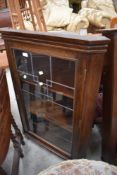 An early 20th Century stained frame corner wall display having leaded glass door