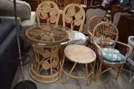 A selection of wicker conservatory style furniture including glass top table