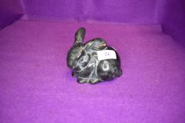 A cast metal baby rabbit having marble effect.