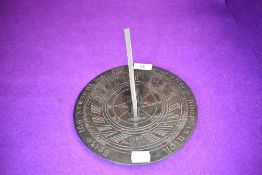 A bronze sundial,with a pierced gnomon,signed and dated 'Thomas Grice 1705'with inscription