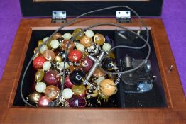 A musical jewellery box containing a small selection of costume jewellery necklaces